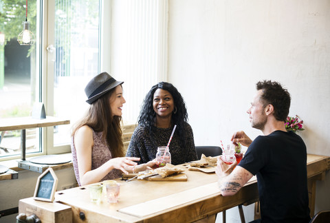 Freunde treffen sich im Café, essen und haben Spaß, lizenzfreies Stockfoto