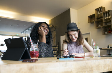 Zwei Freunde benutzen ein digitales Tablet in einem Cafe - ONF000984