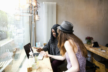 Two friends having a meeting cafe, using laptop - ONF000990