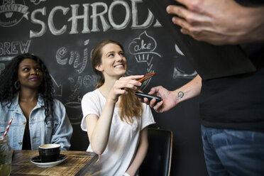 Freunde im Café bezahlen mit Smartphone - ONF001004