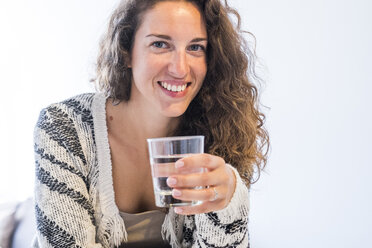 Porträt einer lächelnden Frau, die ein Glas Wasser hält - SIPF000649