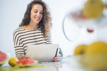 Portrait of smiling woman using tablet at home - SIPF000650