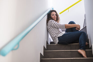 Young woman at home sitting on stairs - SIPF000655