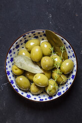 Green olives thyme and bay leaves in bowl - SBDF003039