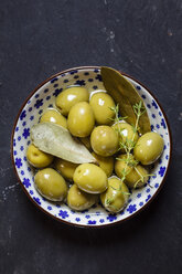 Grüne Oliven, Thymian und Lorbeerblätter in einer Schüssel - SBDF003039