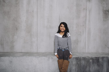 Female Indian sitting on concrete wall - GCF000224