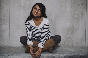 Female Indian sitting on concrete wall - GCF000227