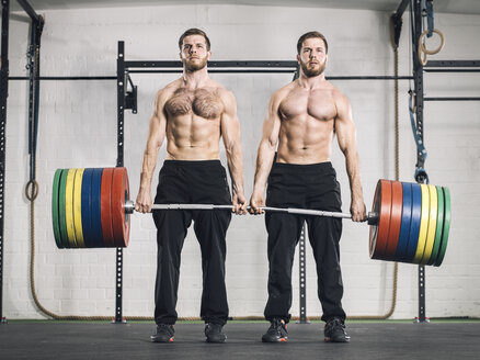 Twin brothers weightlifting in gym - MAD001005