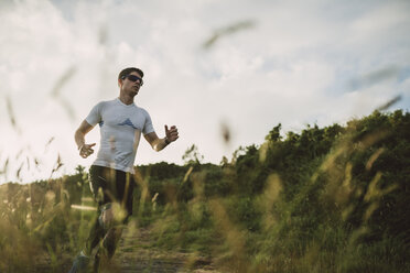 Trail runner man training in nature in the evening - RAEF001282