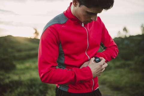 Trailrunner, der auf seine Uhr schaut, um mit dem Training zu beginnen, lizenzfreies Stockfoto