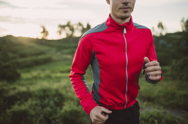 Trailrunner Mann beim abendlichen Training in der Natur - RAEF001298