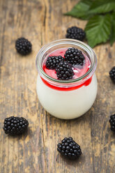 Glass of natural yoghurt with sirup and blackberries - LVF005134