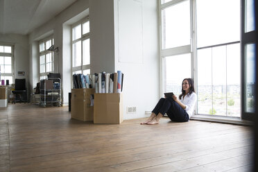 Businesswoman working barefoot on floor - FKF001959