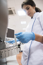 Laboratory technician in analytical laboratory putting samples in autoanalyzer - ABZF000831