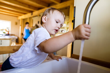 Kleiner Junge spielt mit Wasserhahn in Küche - HAPF000607