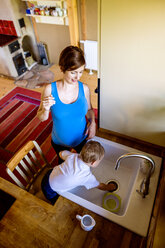 Kleiner Junge hilft Mutter in der Küche beim Abwasch - HAPF000608