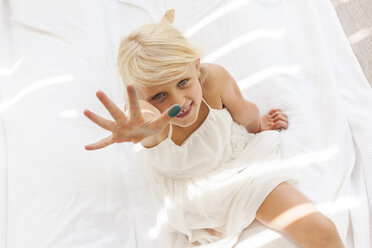 Portrait of little girl in underwear lying on bed at home stock photo