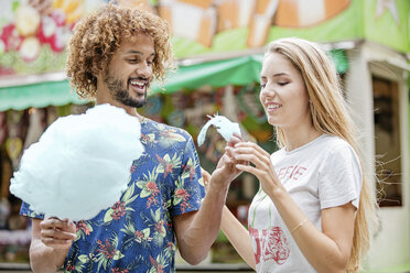 Junges Paar isst Zuckerwatte auf einem Jahrmarkt - GD001079