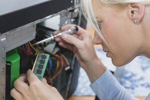 Frau beim Zusammenbau eines Speichers mit wahlfreiem Zugriff am Computer - MIDF000773