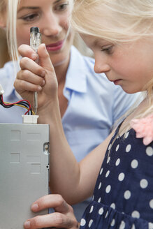 Little girl checking current flow of computer - MIDF000775