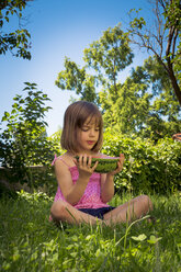 Kleines Mädchen sitzt auf einer Wiese und hält eine Scheibe Wassermelone - LVF005137