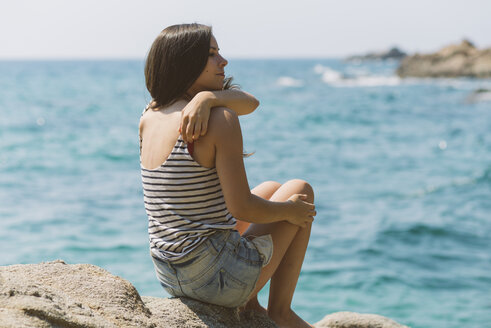 Frau mit Sommerkleidung, die am Strand von Blanes aufs Meer hinausschaut - SKCF000110