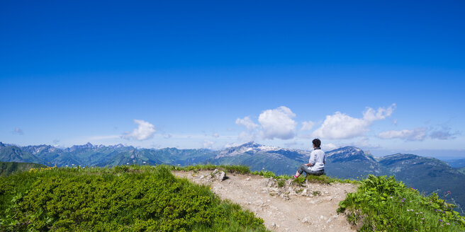 Germany, Bavaria, Allgaeu Alps, Fellhorn, female hiker sitting on viewpoint, view to Soellereck - WGF000905