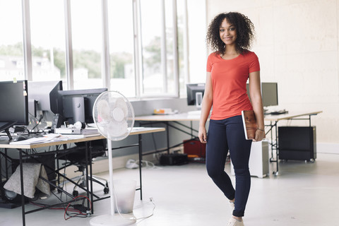 Junge Frau im Büro mit Laptop, lizenzfreies Stockfoto