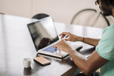 Junger Mann arbeitet am Laptop - RIBF000454