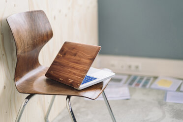 Laptop aus Holz auf einem Stuhl - RIBF000511