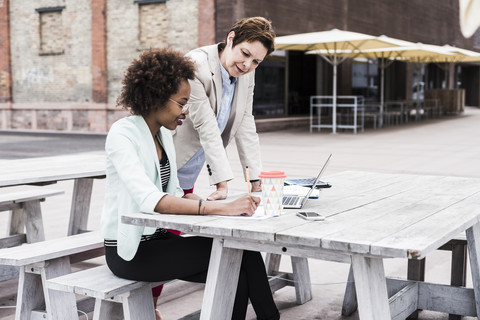 Two businesswomen working on terrace of a pavement cafe stock photo