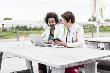 Zwei Geschäftsfrauen arbeiten an einer Terrasse - UUF008178