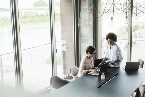 Zwei Frauen arbeiten zusammen in einem Büro, lizenzfreies Stockfoto