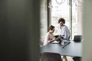 Two women working together in an office - UUF008217