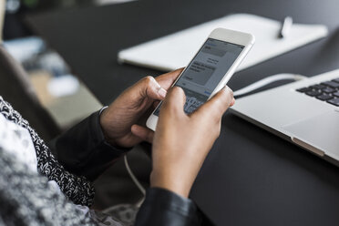 Hands of woman text messaging at desk, close-up - UUF008236