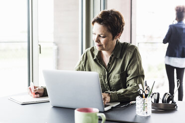 Geschäftsfrau bei der Arbeit am Schreibtisch - UUF008256