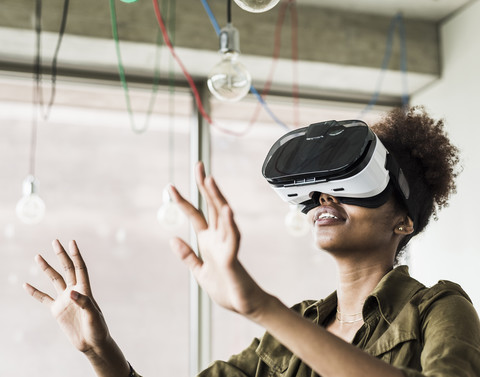 Woman in office using virtual reality glasses stock photo