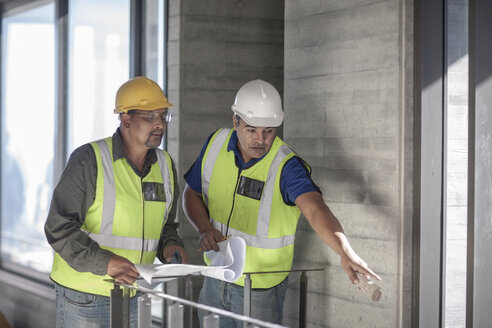 Zwei Bauarbeiter unterhalten sich auf einer Baustelle - ZEF009160