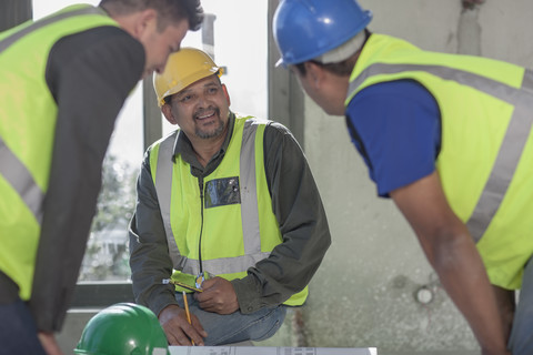 Architekt und Bauarbeiter auf der Baustelle, lizenzfreies Stockfoto