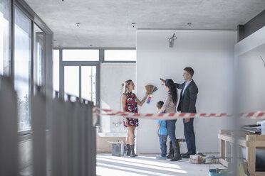 Woman with color sample and family in building shell - ZEF009192