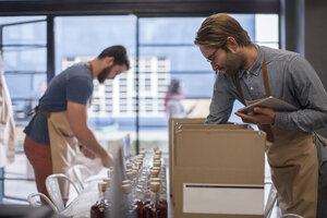 Two colleagues shipping liquor in a distillery - ZEF009237