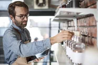 Man reaching out for a jar in distillery - ZEF009270