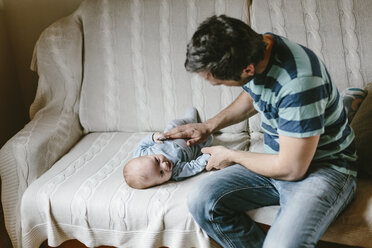 Father with baby boy on couch at home - HAPF000655