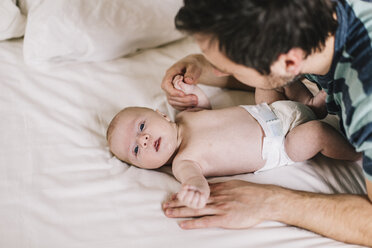 Vater mit kleinem Jungen auf dem Bett liegend zu Hause - HAPF000660