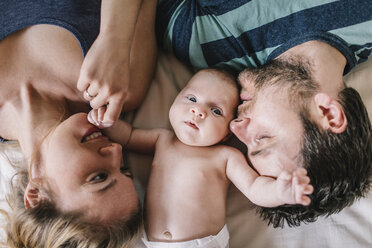 Mutter und Vater mit einem kleinen Jungen auf dem Bett liegend - HAPF000665