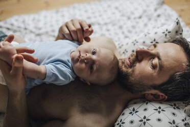 Vater mit kleinem Jungen auf dem Bett liegend zu Hause - HAPF000674