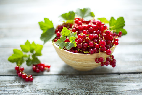 Schale mit roten Johannisbeeren auf Holz, lizenzfreies Stockfoto