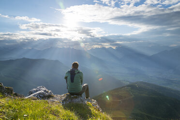 Österreich, Tirol, Wanderer sitzt auf Aussichtspunkt gegen die Sonne - MKFF000314