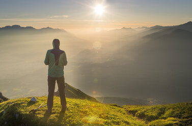 Austria, Tyrol, hiker looking at distance at sunrise - MKFF000319