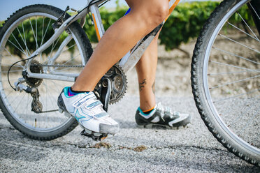 Nahaufnahme der Beine einer Radfahrerin mit Radschuhen - KIJF000617